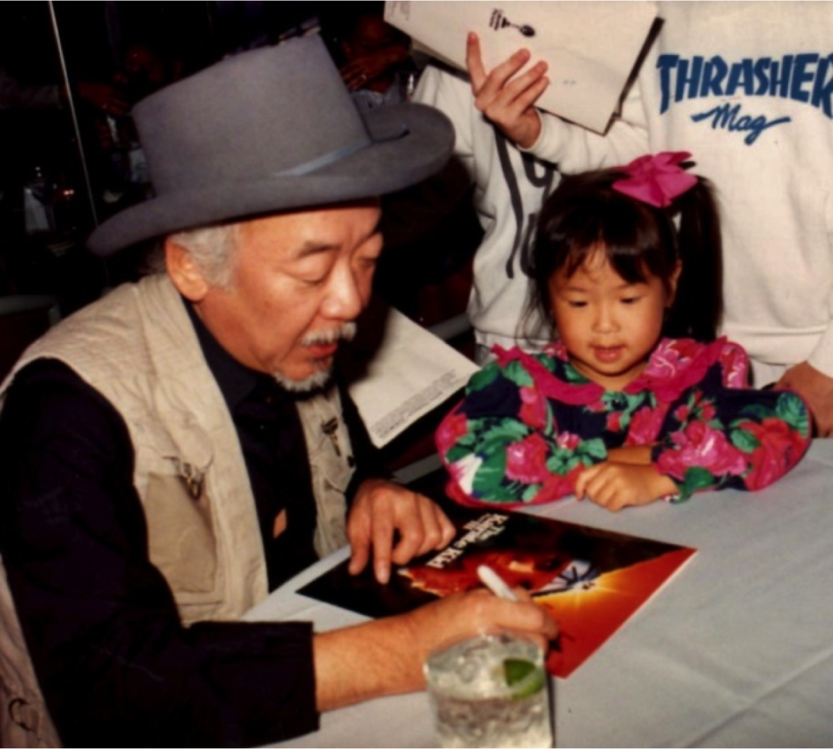 Pat Morita signing an autograph.